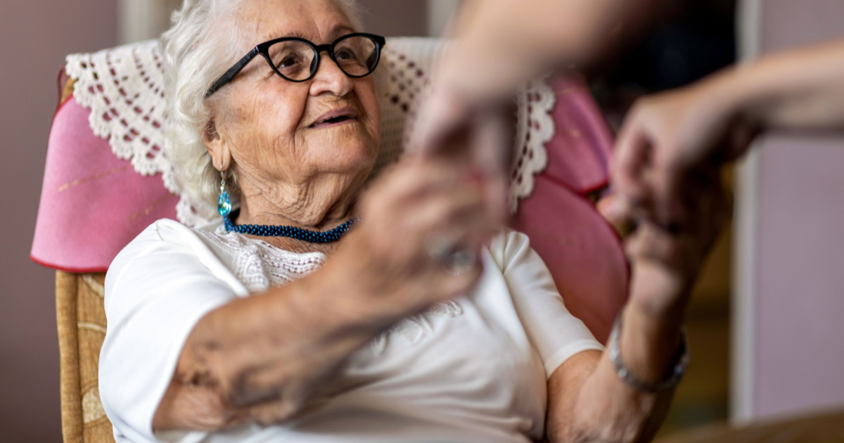 Elderly woman getting help from caregiver for in home care for elderly