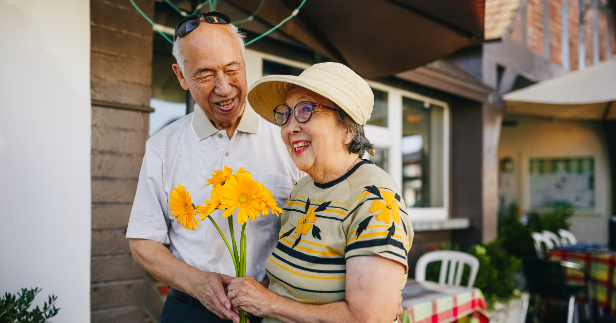 Elderly couple holding flowers