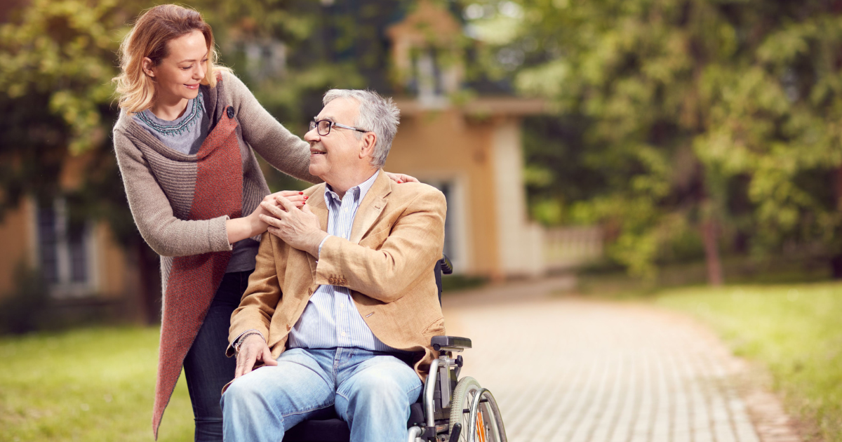Elderly man having conversation with caregiver