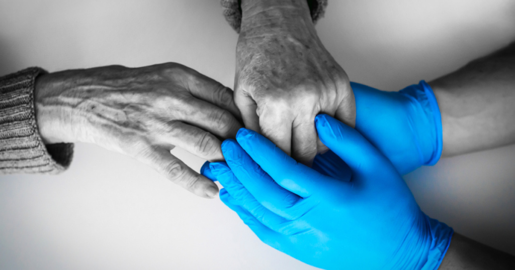 Elderly hands holding gloved hands for home help after surgery