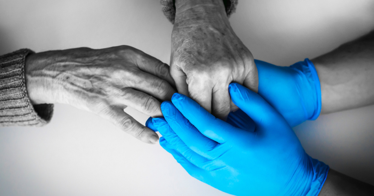 Elderly hands holding gloved hands for home help after surgery