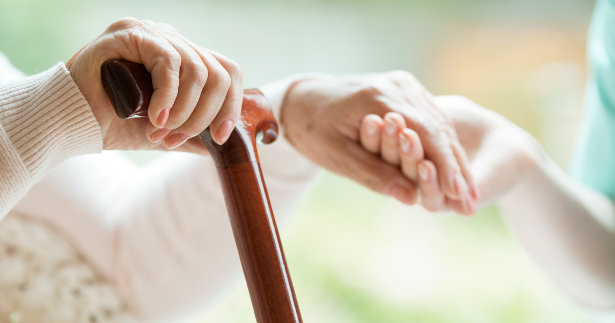 Holding hands with elderly in home assisted living